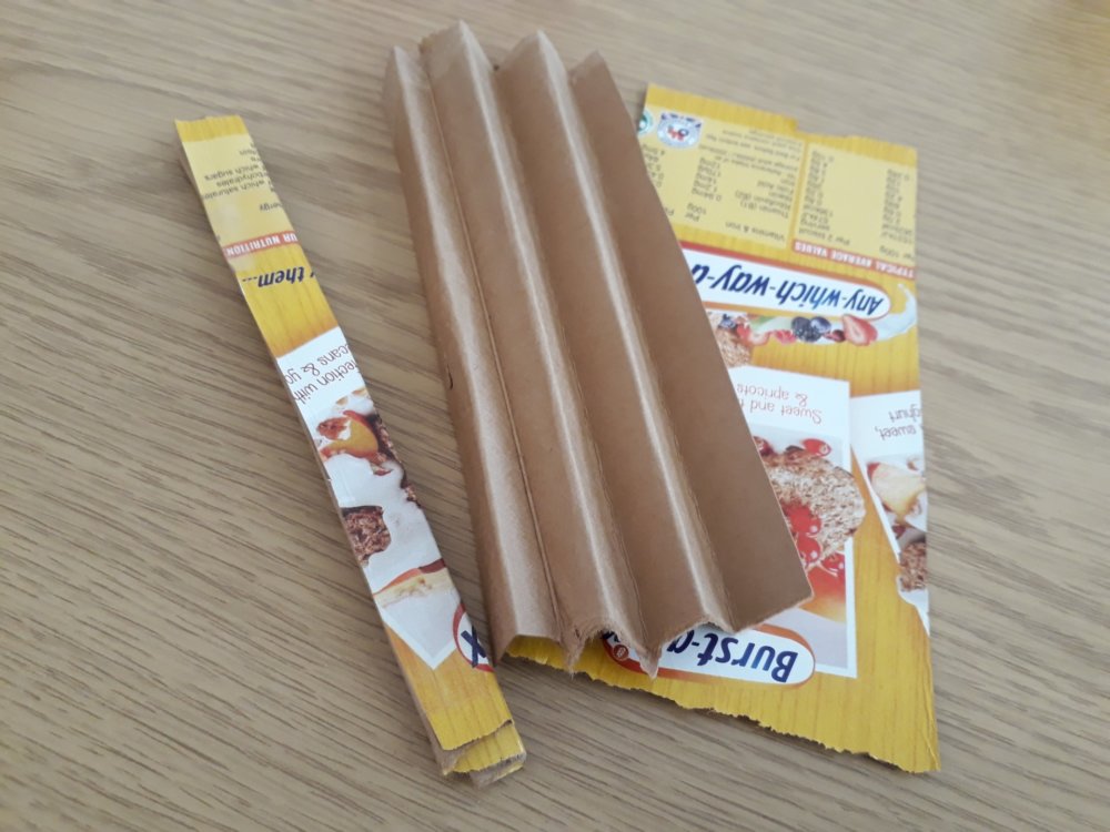 The process of making a handle from card, with some cereal packaging, it folded in a concertina and it tapes together to make a handle.