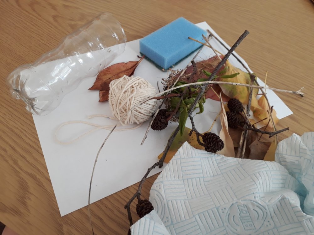 An array of different materials: leaves, a spone, string, a plastic bottle, paper, sticks, tissue
