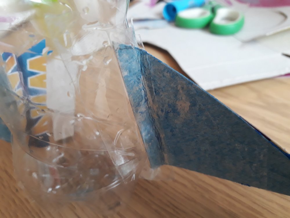 Triangular wing taped to the plastic bottle