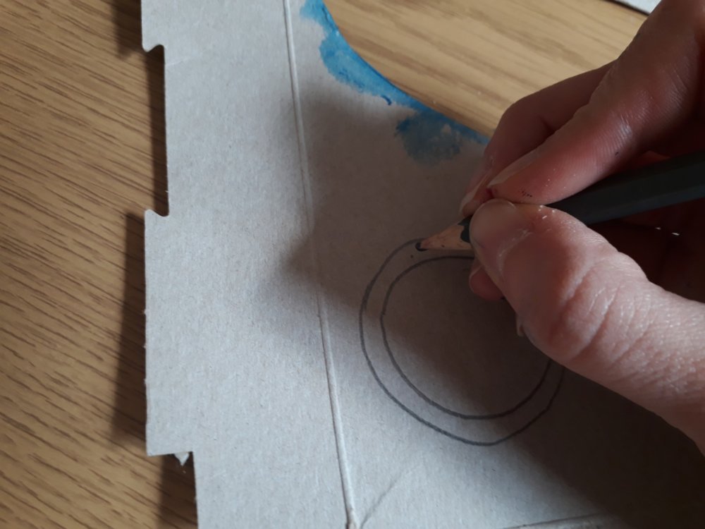 A hand drawing a circle on card