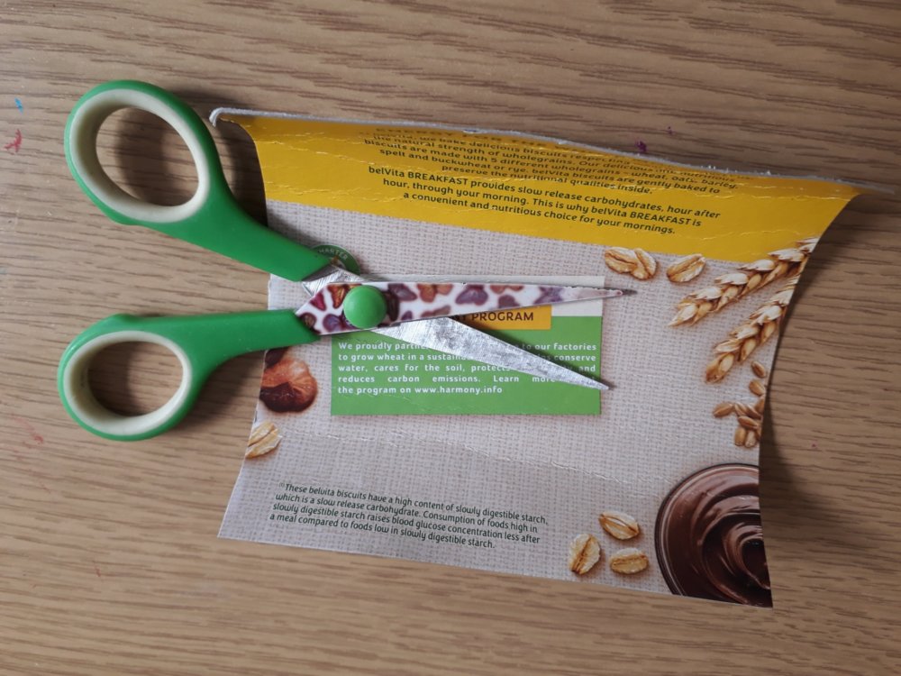 Scissors and a curled piece of cardboard