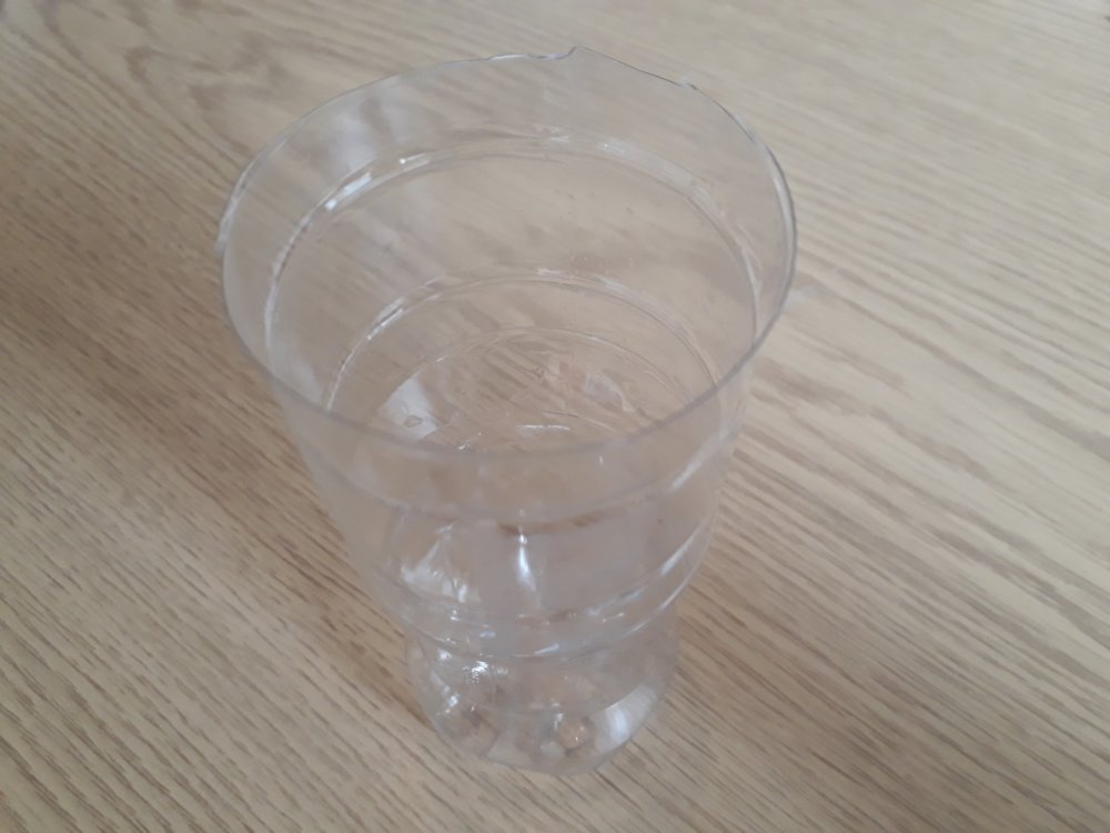 A plastic drinking bottle with the top cut off