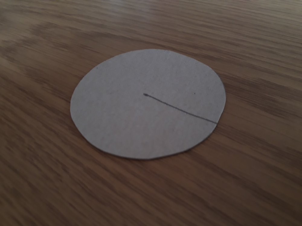 A circle cut from cardboard with the radius drawn on