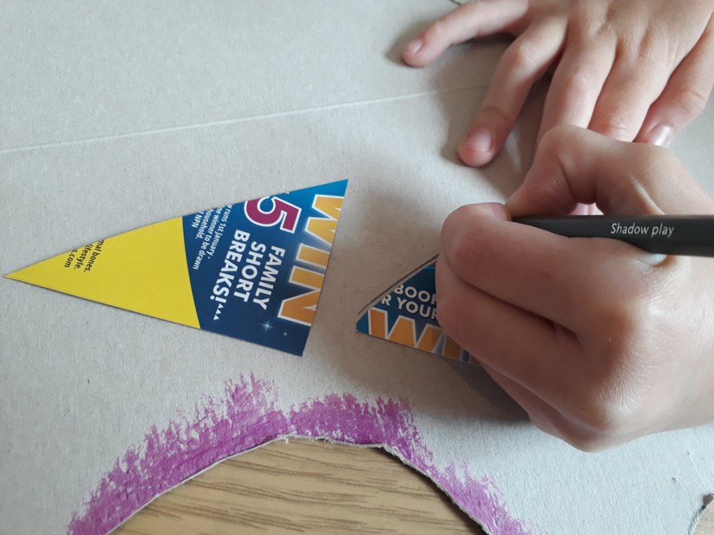 A hand drawing around cardboard triangles