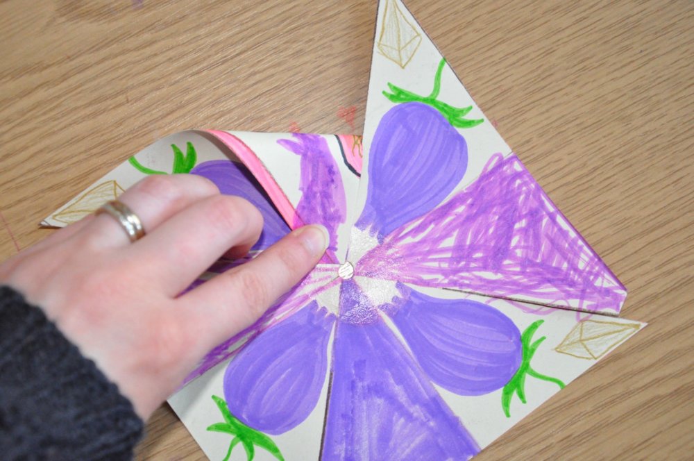 A hand holding the flap into the centre of the wheel.