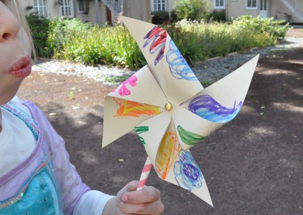 A child blowing a flower wheel.