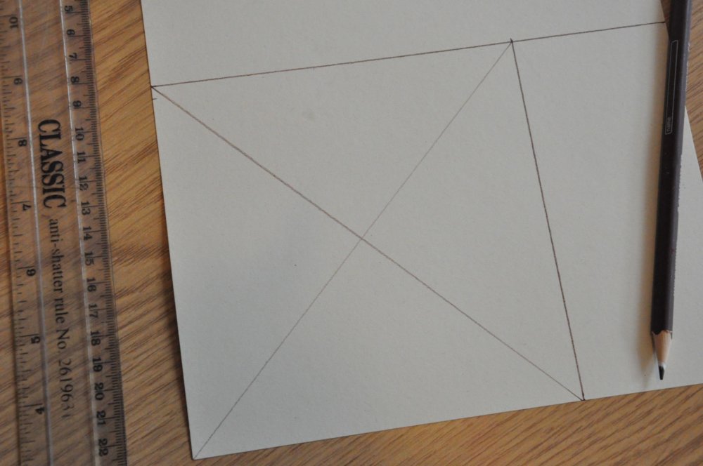 A square on a sheet of paper with a cross drawn on it from each corner.
