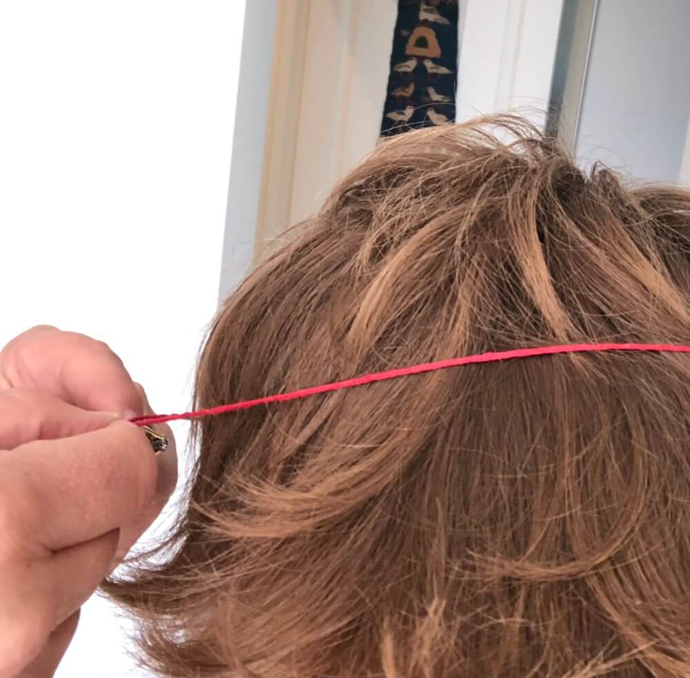 Red string being measured around a head.