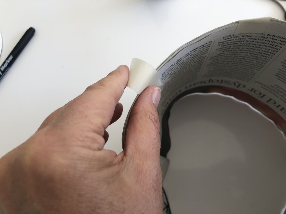 A hand taping the newspaper together
